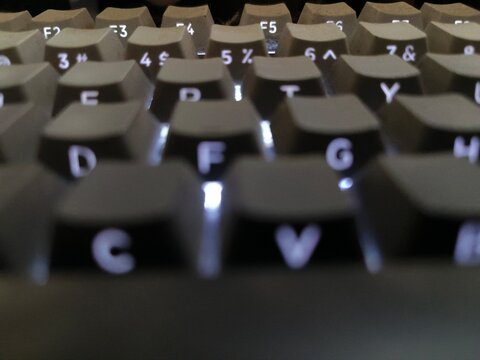 Close up macro shot of illuminated mechanical computer keyboard keys with soft background