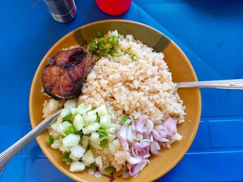 Un plat de riz ,au poisson et salades oignons