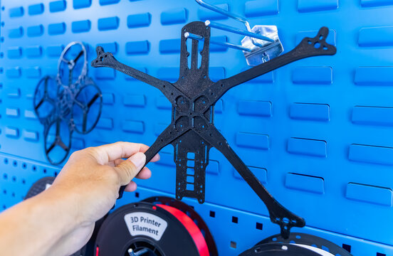 hand holding Drone frame 3d printed by 3D printer. Modern additive technology.