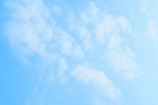White fluffy cloud on clear blue sky background. Clean minimalist sky background with copy space for text or design.