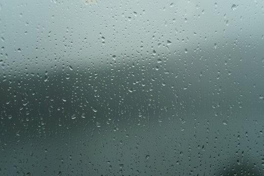 Rain Droplets On Glass Window With Foggy Background