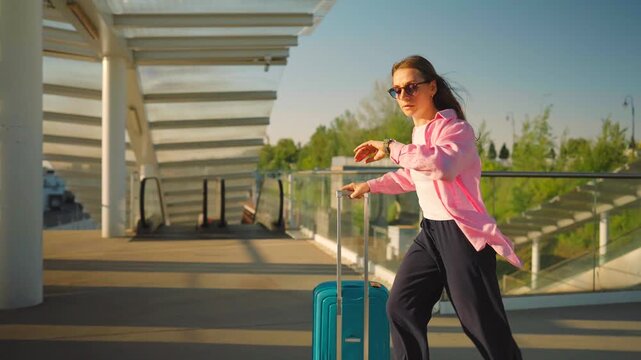 Caucasian woman pulling a suitcase and running, late for flight. 