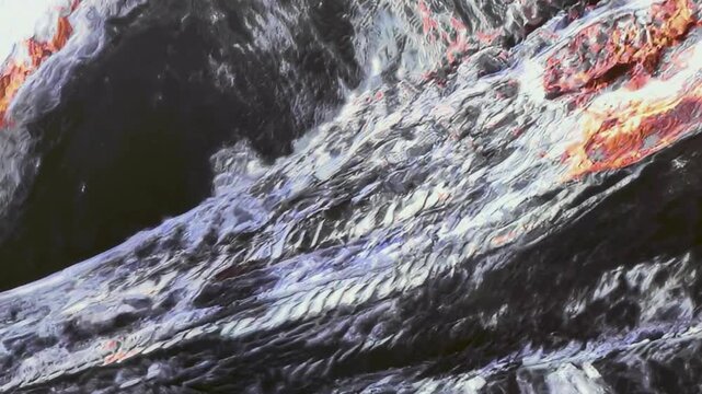 Molten lava flows across a rocky surface beside a dark opening at a volcano