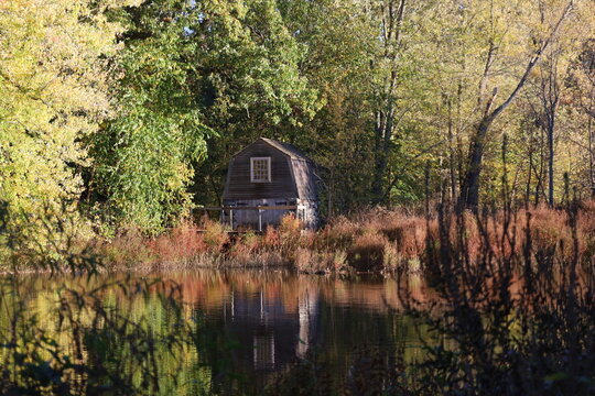 Historic Boathouse by the Calm River Amidst Autumn Foliage in Concord, Massachusetts