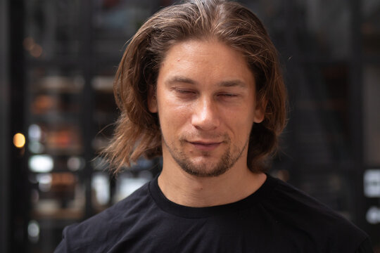 30s caucasian man in casual clothing with eyes closed in a relaxed mood