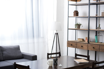 Study space with coffee cup, stationery and notebook on a wooden table in modern apartment  © LIGHTFIELD STUDIOS