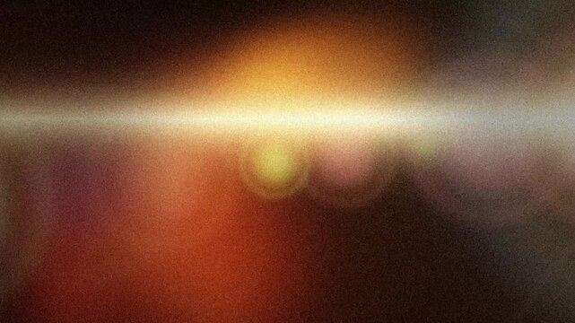 Grainy golden light streak drifting across warm orange blur