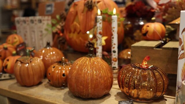 Fall home decorating ideas come alive in a lovely shop display of glazed ceramic pumpkins shimmering amber glass and patterned candles celebrating the fall harvest season