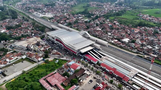 Aerial view of Stasiun Kereta Cepat Padalarang with modern railway tracks and surrounding urban landscape in Padalarang, West Java, Indonesia.
