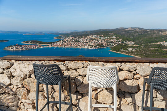 Outdoor bar seating on a rocky terrace overlooks the Adriatic coastline near Primosten, Croatia 