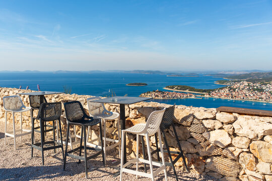 Outdoor bar seating on a rocky terrace overlooks the Adriatic coastline near Primosten, Croatia 