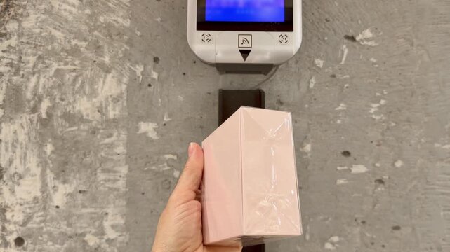 Checking Prices in Fragrance Store .Hand Using Wall Scanner in Cosmetics Shop.Perfume and Eau de Toilette Bottles on Display in Cosmetics Store 