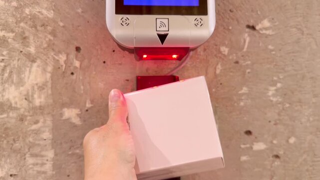 Checking Prices in Fragrance Store .Hand Using Wall Scanner in Cosmetics Shop.Perfume and Eau de Toilette Bottles on Display in Cosmetics Store 