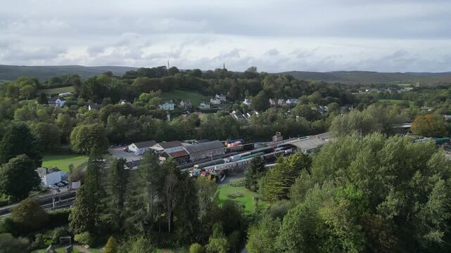 Buckfastleigh, Devon, England: DRONE VIEWS: 1. Stationary steam engines & carriages at Buckfastleigh railway station; 2. Traffic on the Devon Expressway (A38); 3. Houses in the town of Buckfastleigh.