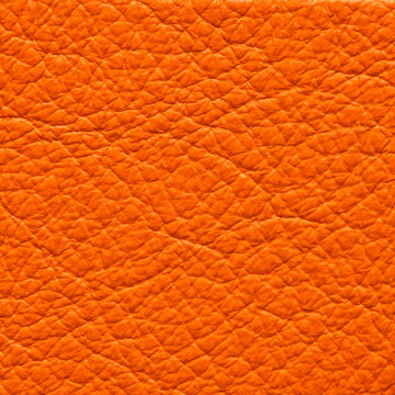 Vibrant orange leather texture background with pebble grain pattern