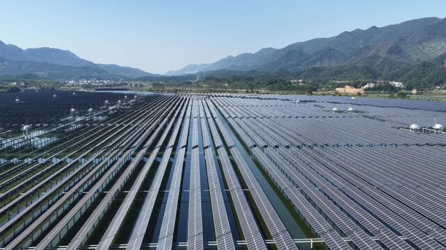 aerial view of floating solar power plant on water surface with mountains background
