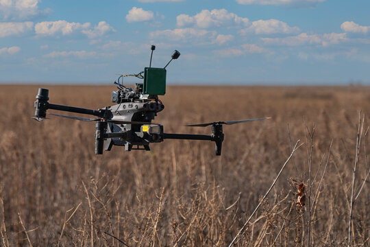 Large relay UAV over Ukrainian farmland, illustrating extended FPV control, contested communications and the use of unmanned technology to reduce exposure of frontline personnel.