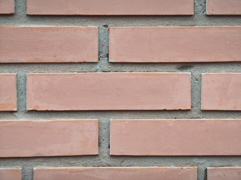 Brick wall surface showcasing a repeating pattern of individual bricks with mortar joints
