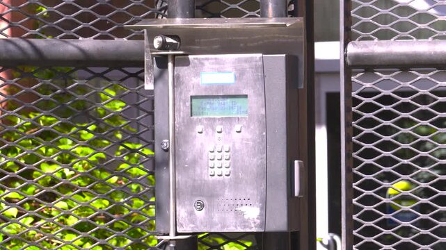 Secure Stainless Steel Intercom Keypad Mounted on Wire Mesh Gate