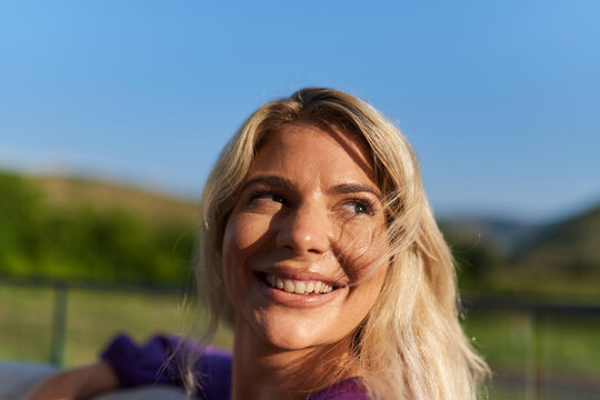 Smiling Blonde Woman Outdoors in Sunny Landscape Looking Up With a Happy Natural Expression