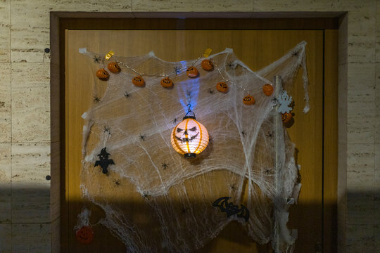 Wooden door decorated with cobwebs pumpkin lights