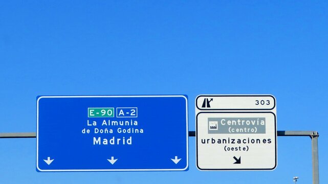 Overhead information signs on the A-2 motorway in Spain ,The large blue sign indicates the straight-ahead direction toward La Almunia de Do&ntilde;a Godina and Madrid. exit 303,October 13, 2026