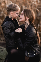 Side profile portrait of mother and son with Halloween skull face makeup holding hands nose-to-nose in a cornfield © Тетяна Хобот