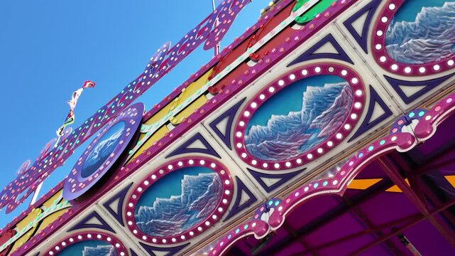 Colorful Amusement Park Ride Facade with Painted Mountain Art and Marquee Lights