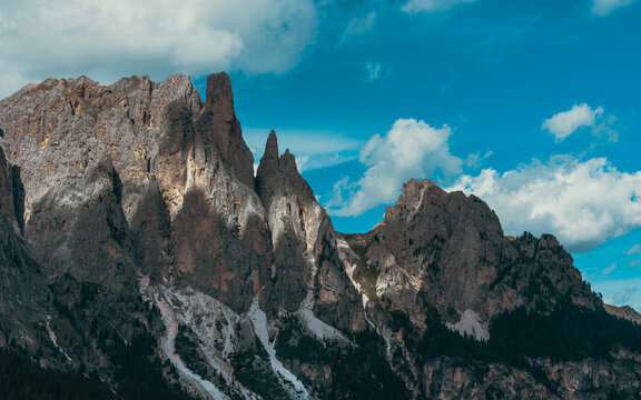 Imponenti pareti rocciose e cime frastagliate sovrastano pendii boscosi, sotto suggestive nubi estive, nei pressi delle Cinque Torri, a Cortina d&rsquo;Ampezzo, nelle Dolomiti venete.