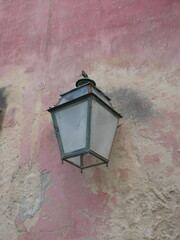 Old street lantern seen against a faded and patchy pink painted wall in a village in the Luberon, France © Alistair MacLean