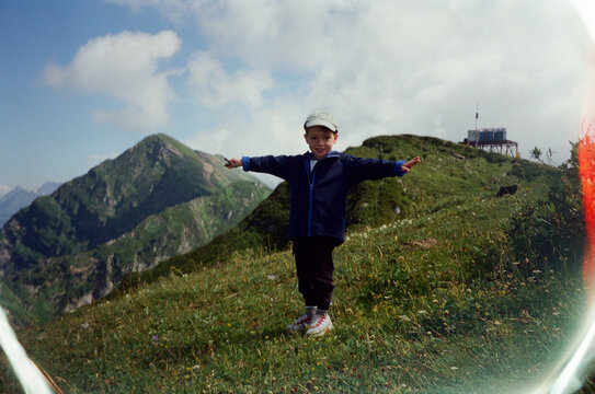 Boy Posing with Arms Outstretched on a Mountain