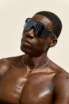 Man wearing sunglasses posing against a light background