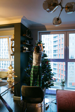 Joyful Moments in a Cozy Apartment While Decorating for Christmas