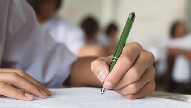 Close-up of Student Hand Holding Pencil Filling Answer Sheet in Final Exam