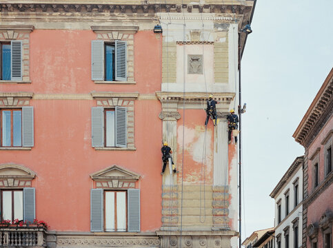 Workers performing vertical access work climbing and restoring palace