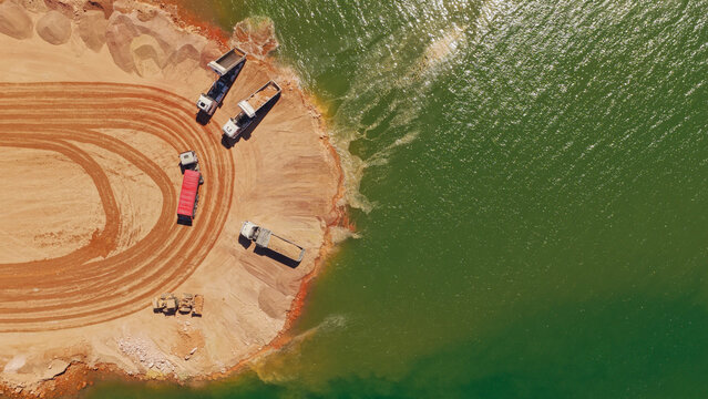 Mining quarry operations with dump trucks by water