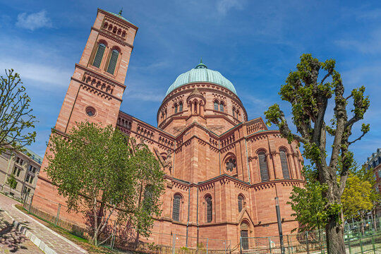 Saint-Pierre-le-Jeune Catholic Church in Strasbourg, France. Striking Neo-Romanesque landmark built from pink Vosges sandstone, featuring a grand dome and tall tower.