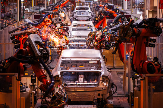Automated car body production line in automobile factory, industrial robotic arms assembling vehicle chassis, smart manufacturing