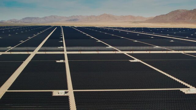 Drone flying along an access road through a huge desert solar farm