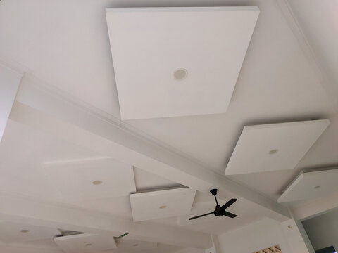 Modern minimalist white false ceiling design with square drop panels and recessed LED downlights in residential interior.