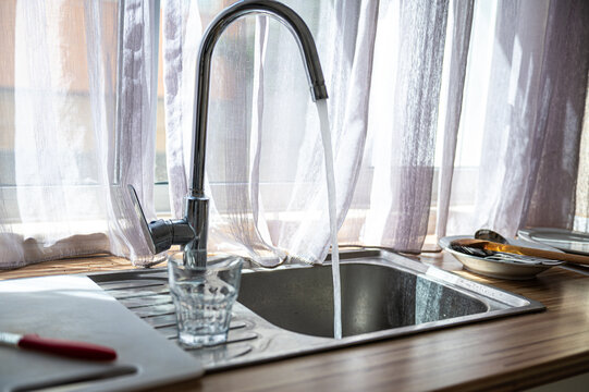 Kitchen sink and faucet beside a window during daytime