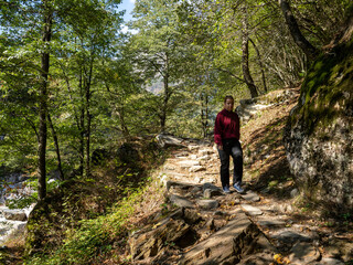 Hiker on Verzasca River trail (Sentiero Verzasca) from Sonogno to Lavertezzo, Switzerland © Catalin