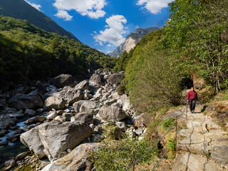 Hiker on Verzasca River trail (Sentiero Verzasca) from Sonogno to Lavertezzo, Switzerland © Catalin