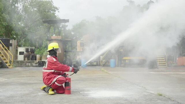Firefighting Training Rescue Expert Demonstrates Safety Standards During Emergency Drill With Protective Equipment, Smoke, Water Hose, Firefighter Suit, Industrial Facility, Focused Response Skills