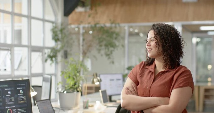African American adult woman standing at desk with laptop, facing window, camera reframing