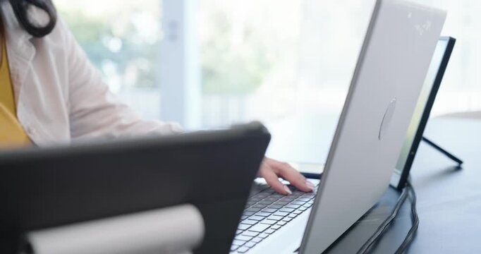 Camera pulling back is showing laptop, monitor with user at desk is typing and updating charts