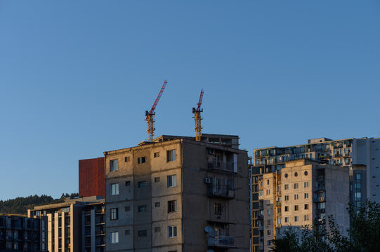 September 23, 2026, Tbilisi, Georgia: City apartment buildings and construction cranes under clear blue sky