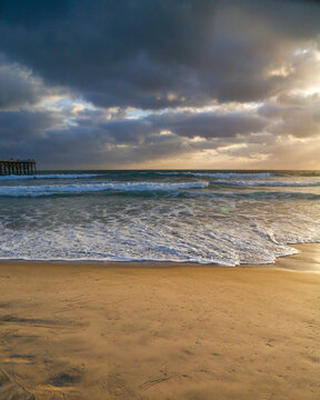 Moody stormy peaceful otherworldly ocean shoreline with waves during sunset on the beach in San Diego southern california