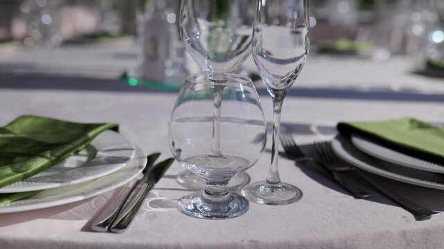 Wine goblets and champagne flute gleaming in sunlight. Close-up of formal banquet table setting