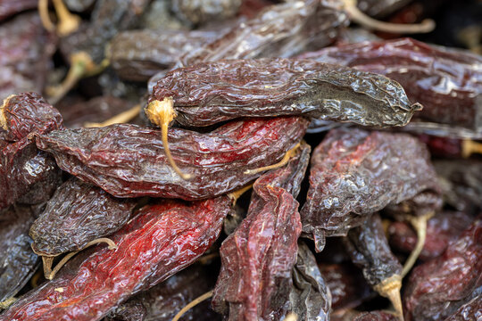 Dried red chili peppers displayed at a market in Huancayo, Peru. Detailed close-up of whole dehydrated peppers with deep red and brown tones, showing the wrinkled texture.
